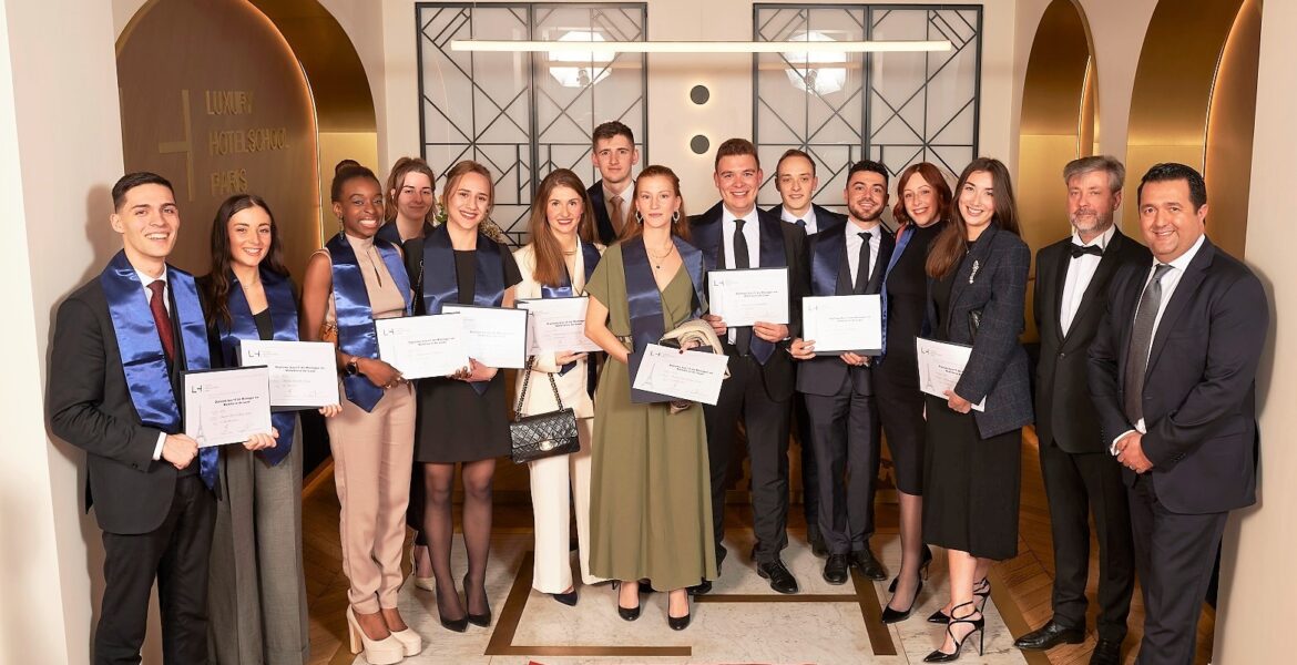 Photo d'étudiants montrant leur diplôme à la main à l'accueil de l'école - Luxury Hotelschool